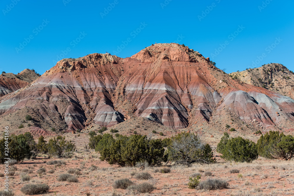 Fototapeta premium Colorful mountain peak under a perfect blue sky in the high desert near Abiquiu, New Mexico in the American Southwest