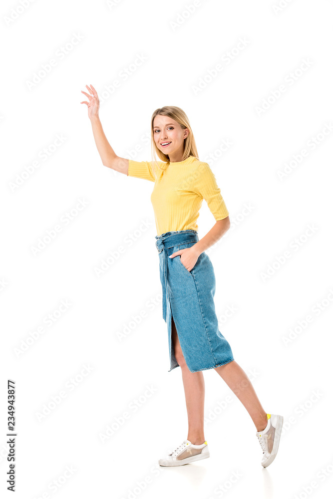 full length view of smiling young woman waving hand and smiling at camera isolated on white full length view of smiling young woman waving hand and smiling at camera isolated on white