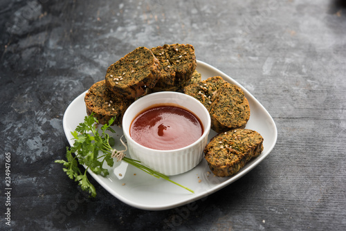 Cilantro cake or Kothimbir Vadi is a popular maharashtrian cuisine made with cilantro leaves. served with tomato ketchup. selective focus photo