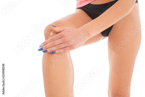 Woman applying body cream on her leg in bedroom, closeup © bobanphotomkd