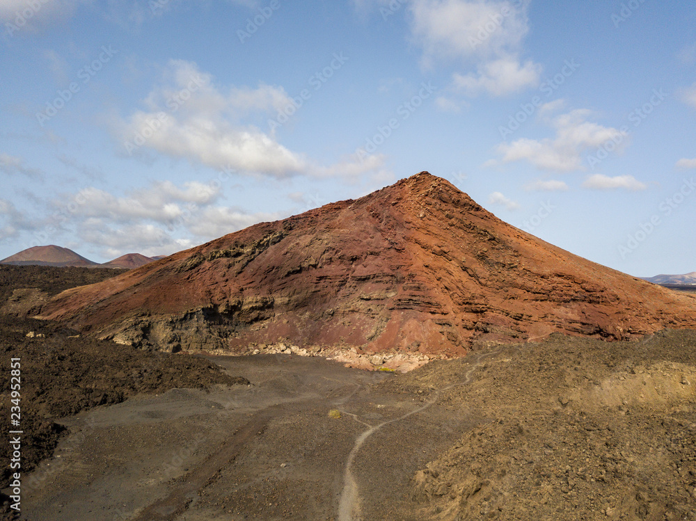 Vista aerea della montagna Bermeja di un color rosso intenso, circondata da campi di lava. Lanzarote, Isole Canarie, Spagna