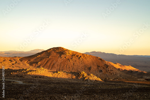 golden morning light on red earth hill  mountains  Eastern Sierra Nevada  California  USA