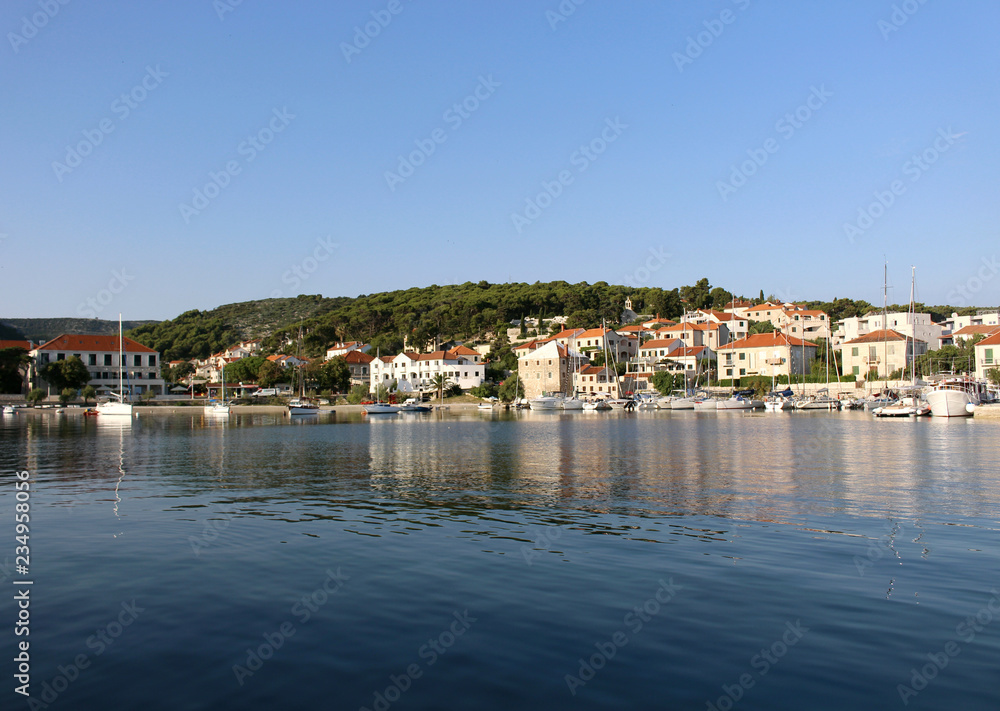Beautiful old houses built on rock in the harbor of a small town Postira - Croatia, Brac island.