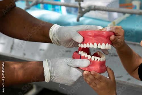 Rio de Janeiro, Brazil - november 22, 2018: Health professional teaches how to floss with a dental arch replica