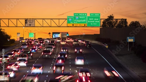 Phoenix AZ Interstate Rush Hour Vehicle Traffic Timelapse at Sunset with I17 Signage as Cars are Driving through Arizona under a Vibrant Orange Sky photo