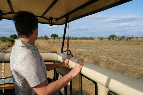 Young man discover african nature by car Tanzania safari