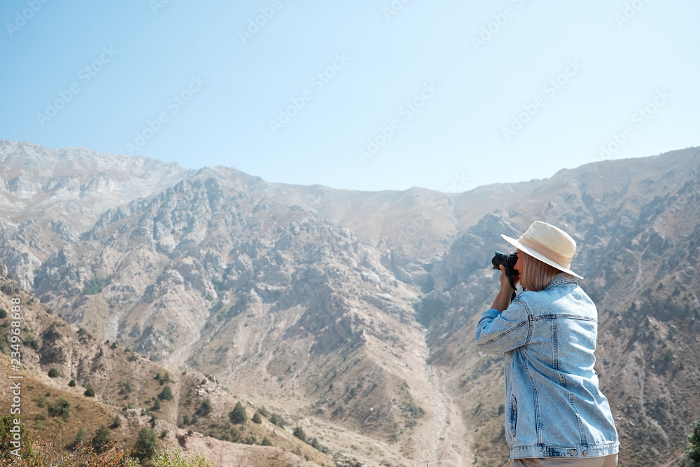 Hiker photographer taking picture of the landscape with mountains