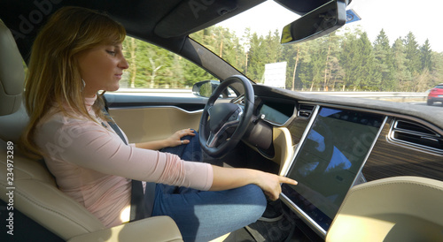 Wallpaper Mural CLOSE UP Smiling woman setting up the navigation in her high tech autonomous car Torontodigital.ca
