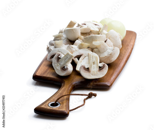 Raw sliced mushrooms and onion on cutting board isolated on white.