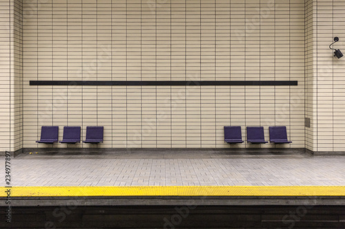 Two sets of purple chairs attached to tiled wall