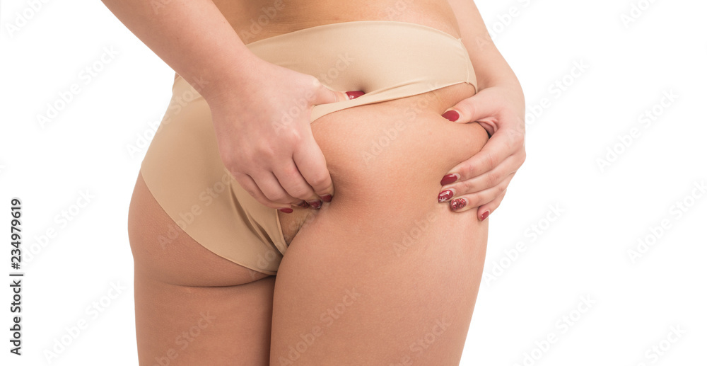 young woman pinching fat on her buttocks on white background