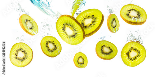 Kiwi slices falling into water and sinking background fruit product
