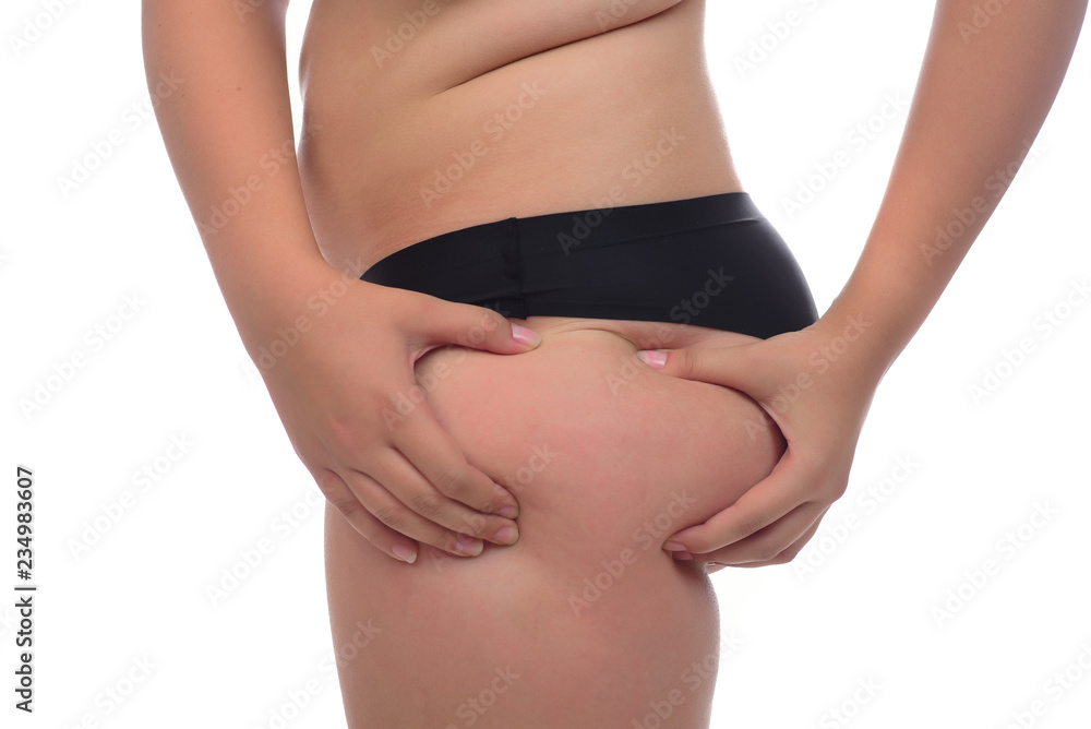  young woman pinching fat on her buttocks on white background