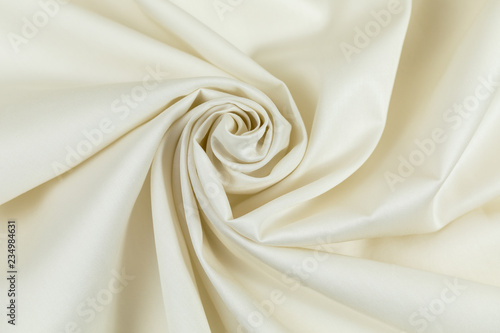 White sateen fabric is put by folds in the form of a spiral with a shade photo