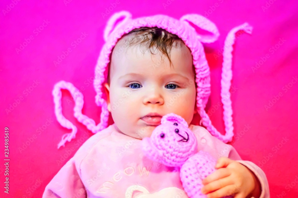 Sweet and adorable blue eyed Caucasian three months old newborn infant baby girl with a pink teddy bear isolated on a pink background. It's a girl concept. Infant with a serious look idea. Sweet and adorable blue eyed Caucasian three months old newborn infant baby girl with a pink teddy bear isolated on a pink background. It's a girl concept. Infant with a serious look idea.