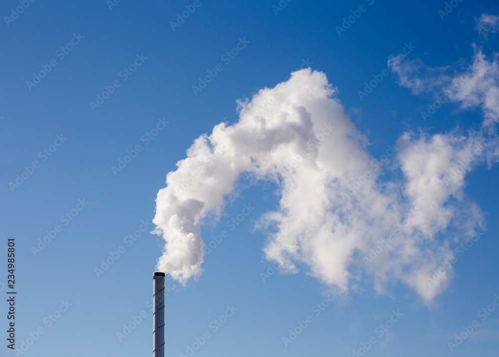 White smoke is coming out of the stack, blue sky background. White smoke is coming out of the stack, blue sky background.