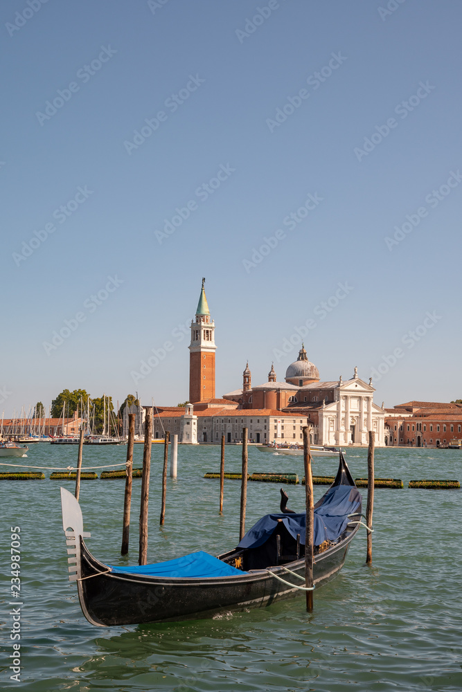 Gondola docked on a Venetian canal with St George Major Island in the background, Venice, Italy