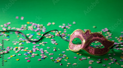 Carnival mask and confetti on green background, banner