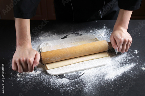 Woman preparing buns from puff pastryat table in bakery. The cook preparing buns at table in bakery. Cooking Process Of Apple Roses. Step four prepare the dough for baking. Cooking Process Concept photo