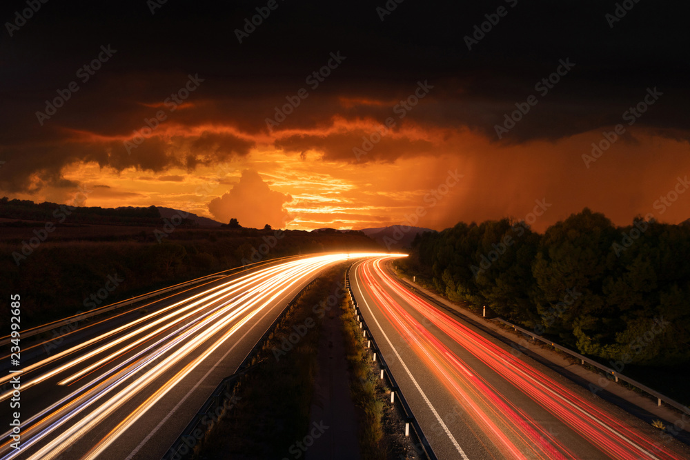 Highway With Traffic Light Trails and Sunset and Storm in Barcelona Province (Spain)