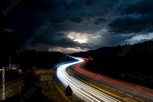 Highway With Traffic Light Trails and Storm on the Horizon in Barcelona Province  Spain 