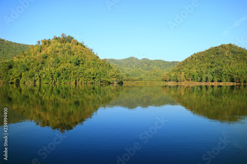 Stunning view of the reflections of mountains on Hoob Khao Wong Reservoir, Suphanburi province, Thailand