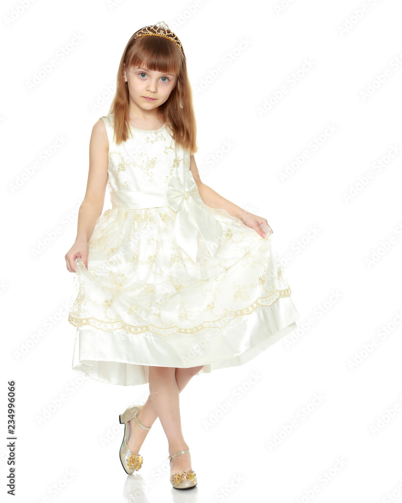 The girl is holding the edges of the dress with her hands.