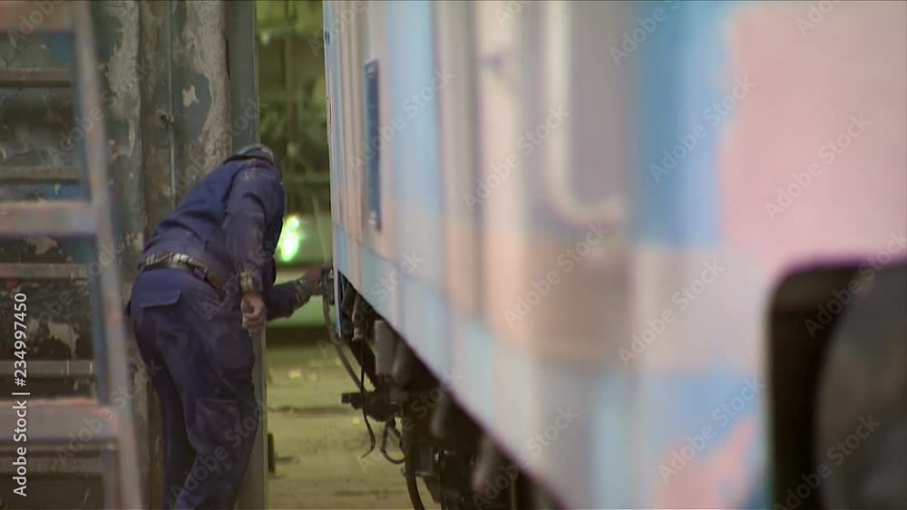 Trains production.Train factory. Worker grinds a metal plate on the train Trains production.Train factory. Worker grinds a metal plate on the train