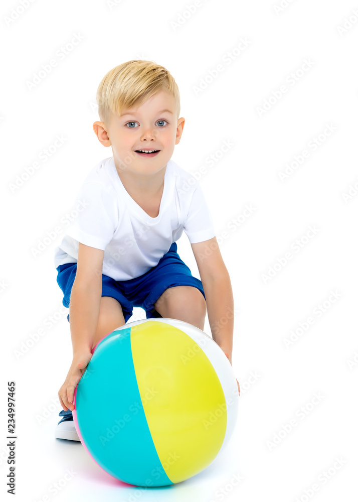 A little boy is playing with a ball. A little boy is playing with a ball.