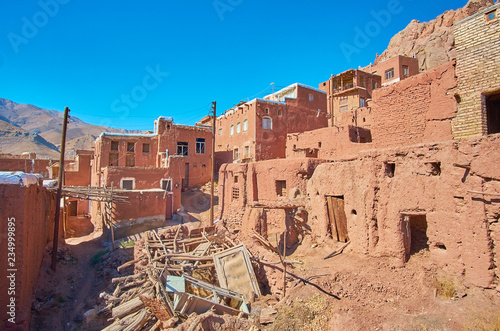 The rubbish dump in old street of Abyaneh mountain village with preserved medieval houses and abandoned buildings around it, Iran. photo