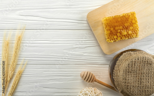 Top view of Honey comb and glass honey jar on wooden background