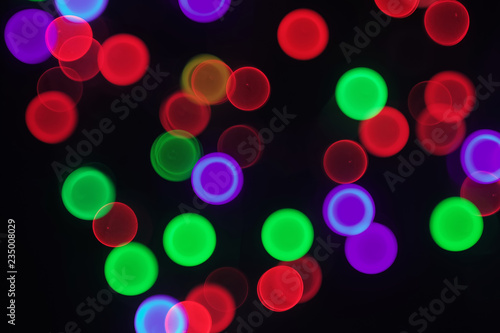 Abstract blurred colorful bokeh circles on black background 