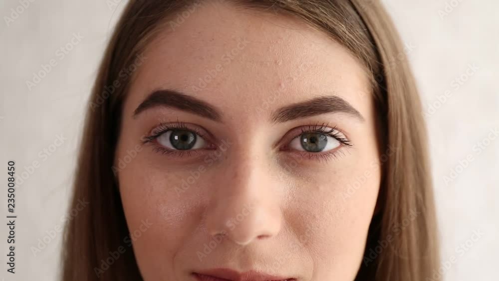 Young woman looking at camera on white background, closeup view
Young woman looking at camera on white background, closeup view