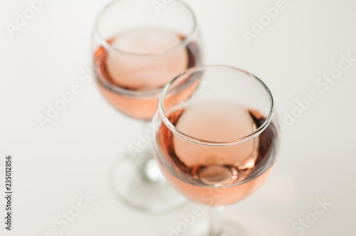 Transparent glass of wine. Pink wine. Festive mood. Alcohol for a group of friends. Delicious drink. Light background. Noble drink. Lavender and rose wine. Wine from lavender