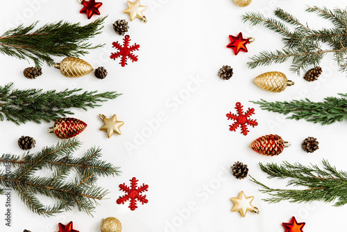 Christmas composition. Frame from christmas red and gold decorations, fir tree branches, pine cones on white background. Flat lay, top view, copy space