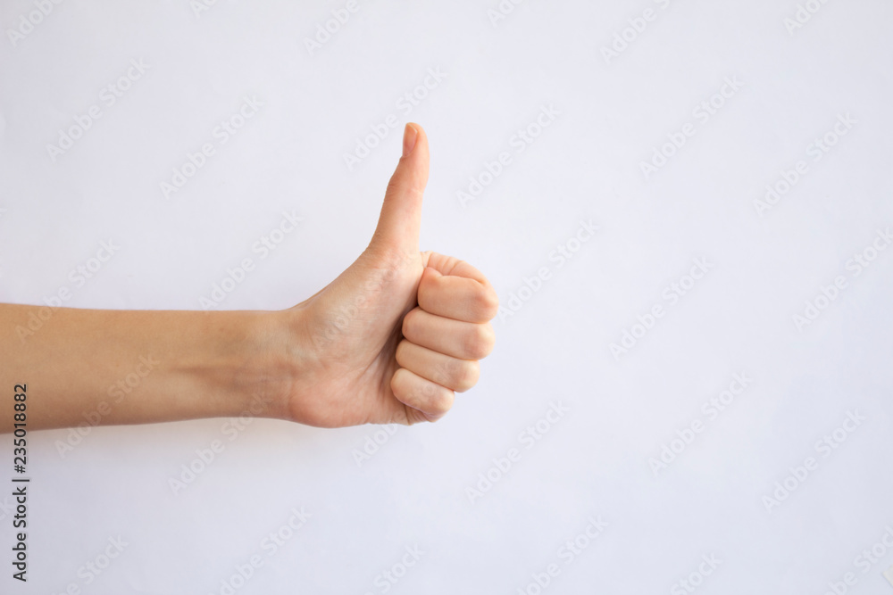 Woman hand with thumb up on gray background