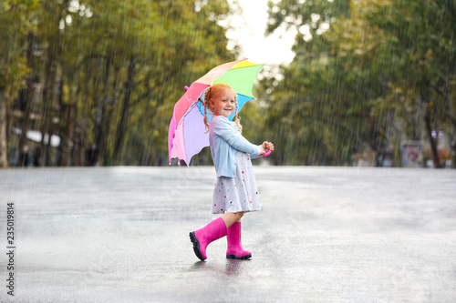 Cute little girl with umbrella in city on rainy day © New Africa