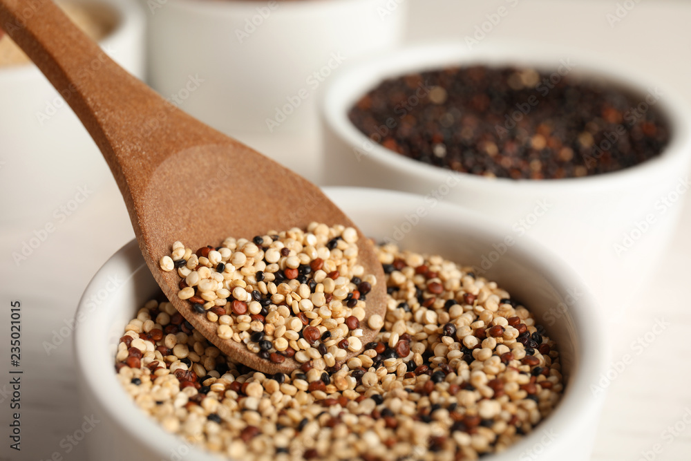 Spoon and bowl with mixed quinoa seeds, closeup Spoon and bowl with mixed quinoa seeds, closeup
