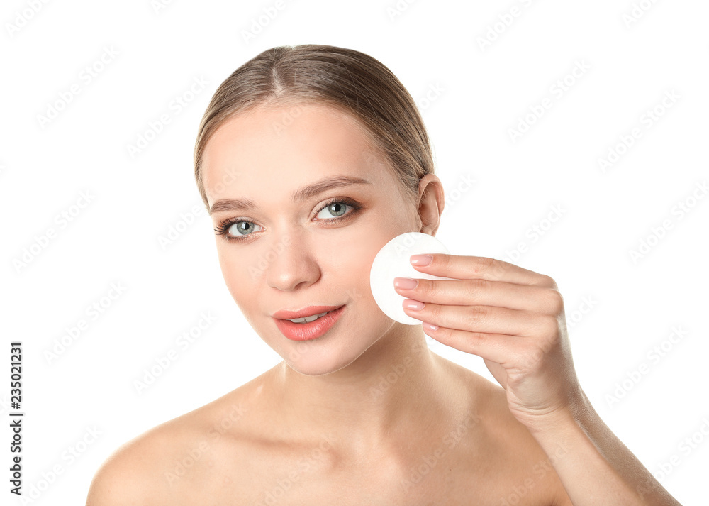 Portrait of beautiful young woman removing makeup with cotton pad on white background Portrait of beautiful young woman removing makeup with cotton pad on white background