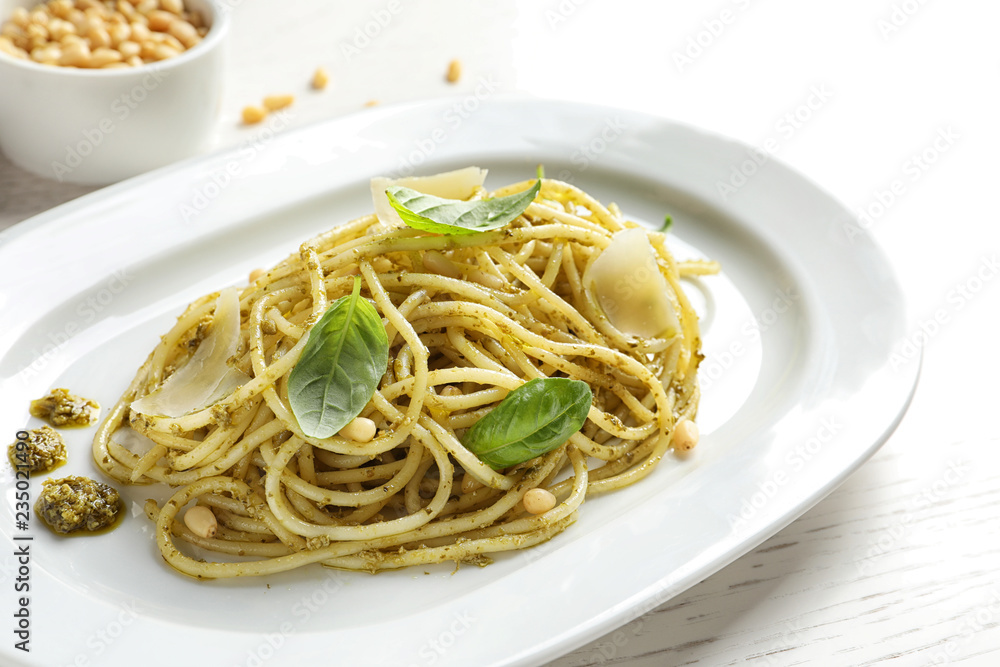 Plate with delicious basil pesto pasta on table
