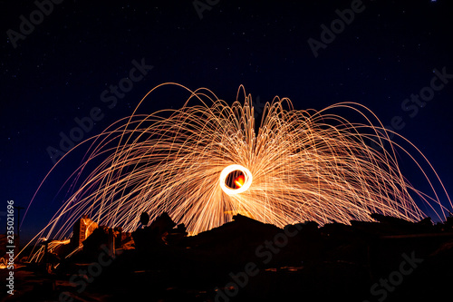 Man on a ruined staircase making rings of fire. photo