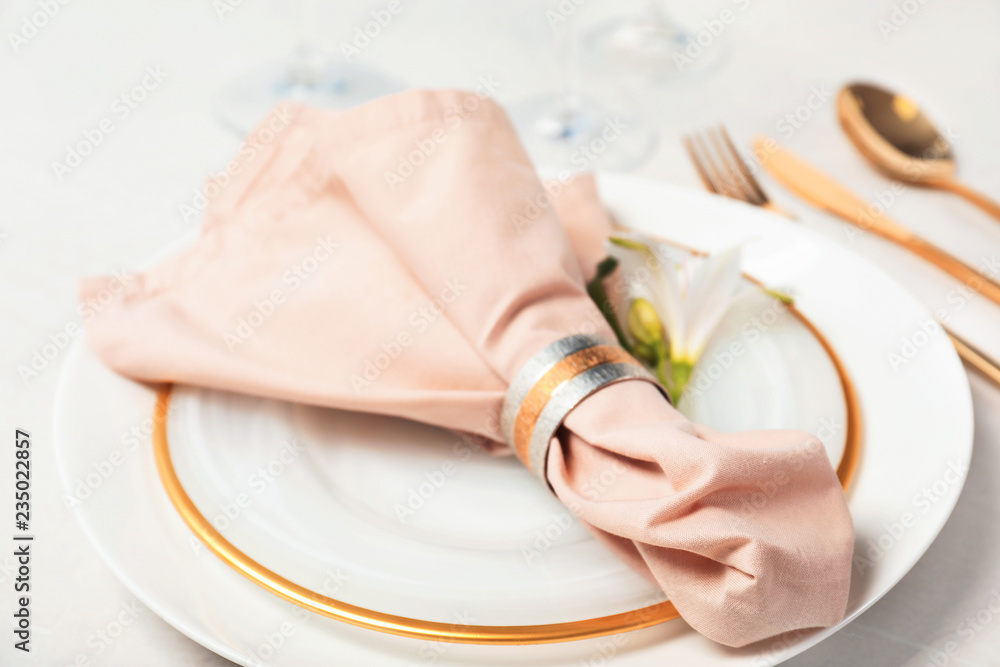 Festive table setting with linen napkin on plates, closeup Festive table setting with linen napkin on plates, closeup