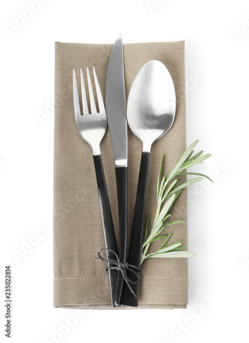 Cutlery and linen napkin on white background, top view