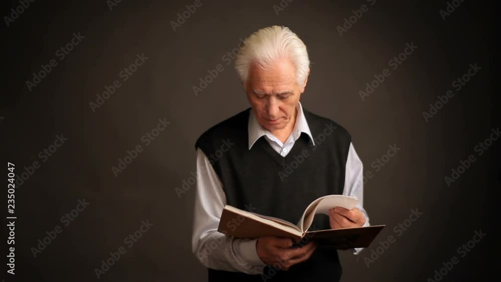 Senior man poses with a book Senior man poses with a book