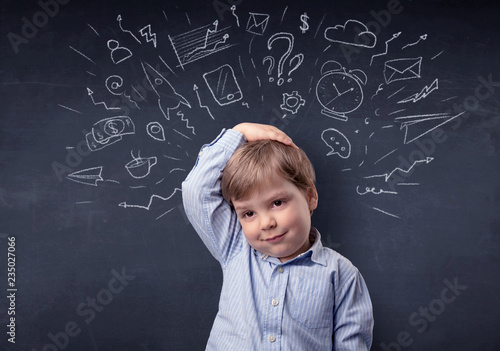 Smart little kid in front of a drawn up blackboard ruminate