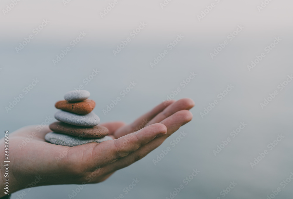 Pile of stacked stones in human hand