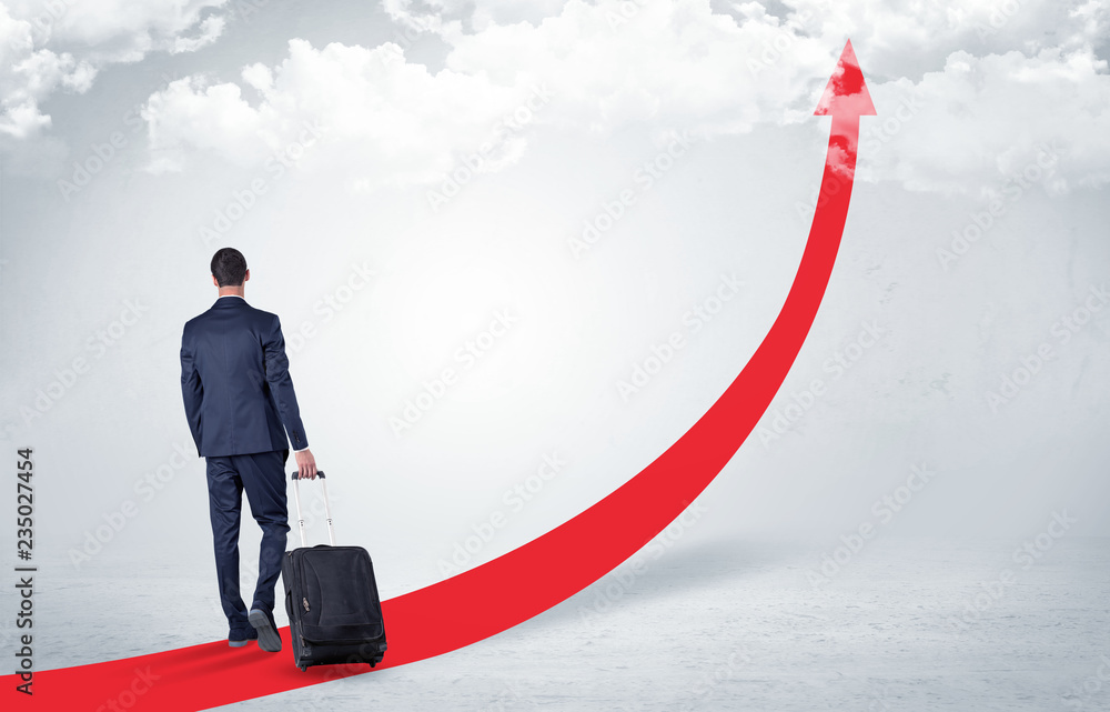 Young businessman with back leaving on the red arrow carpet to the skies with luggage on his hand
Young businessman with back leaving on the red arrow carpet to the skies with luggage on his hand