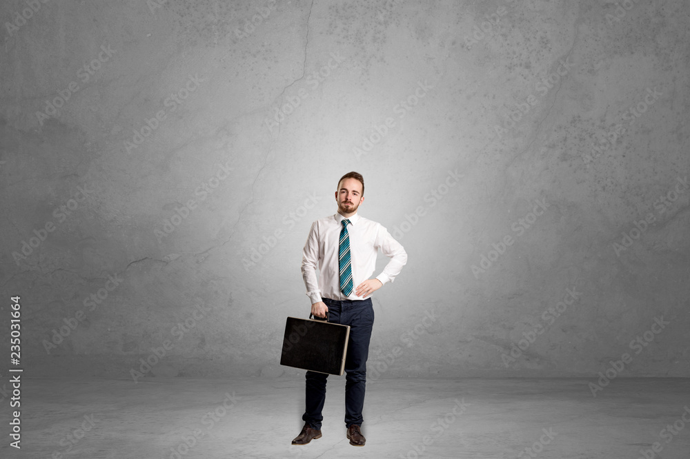 Alone handsome businessman standing in a dark empty room Alone handsome businessman standing in a dark empty room