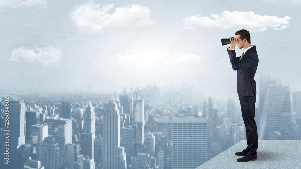 Businessman looking forward to a city with binoculars from skyscraper concept
Businessman looking forward to a city with binoculars from skyscraper concept