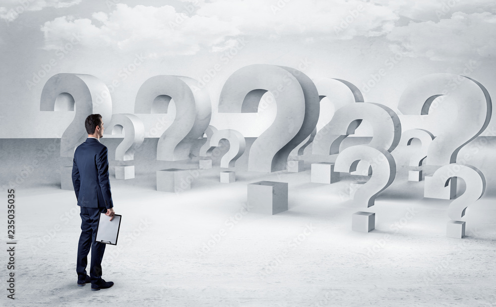 Businessman standing and looking to a bunch of question mark signs
Businessman standing and looking to a bunch of question mark signs